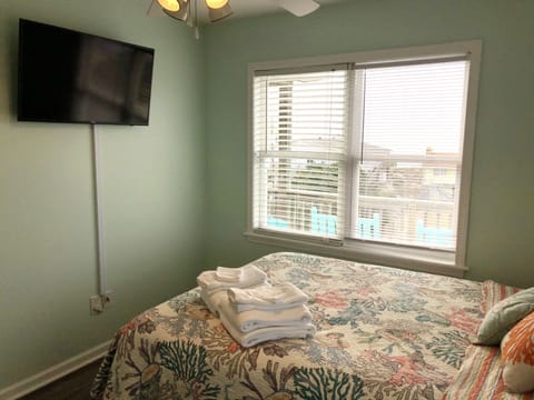 3rd floor ocean view bedroom with queen bed, smart TV, and attached bathroom.