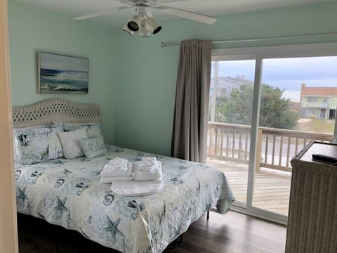 2nd floor bedroom with queen bed, smart TV, and balcony access with Ocean views.