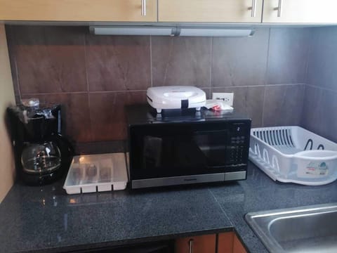 Fridge, microwave, coffee/tea maker, cookware/dishes/utensils