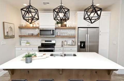 Kitchen island with custom light fixtures and open shelving.