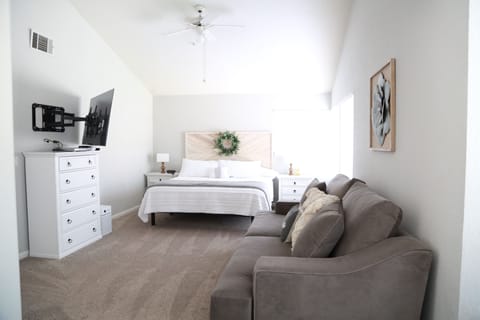 Upstairs master bedroom with king size bed, large adjustable tv and deep couch