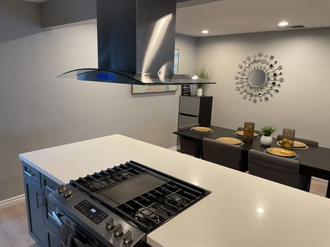 Gas stove burners, within open island designed kitchen.