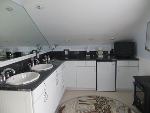 Master bedroom with 2 sinks, mini=fridge, coffee maker, and tv.