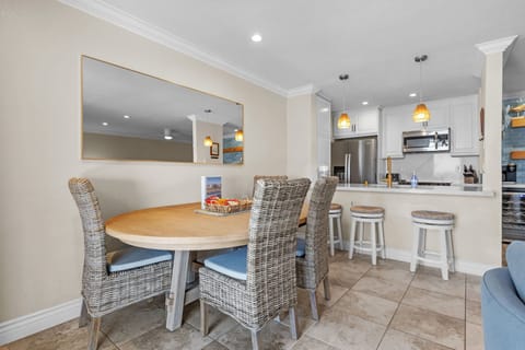Gather around the spacious dining table with comfortable seating and a clear view into the open concept kitchen and living area