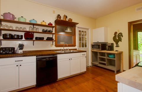 Expansive kitchen w/ open shelves & countertops made from 175-year-old red oak.