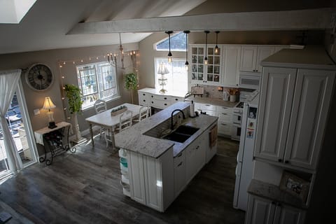 White farmhouse furniture, soft lighting, vintage dishes, and crystal stemware