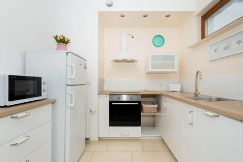A kitchenette with white cabinets, a stove, and essential appliances, providing a clean and functional cooking area.