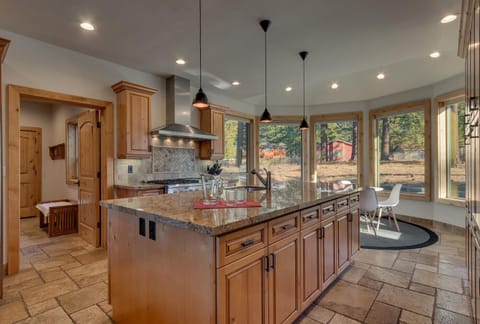 - Kitchen island with granite counters and seating for casual meals
- Large windows bring in natural light and scenic forest views
- Fully stocked space designed for cooking and conversation