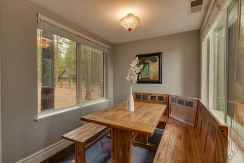 - Cozy breakfast nook with wood benches
- Surrounded by large windows and forest views
- Mountain cabin charm with rustic dining