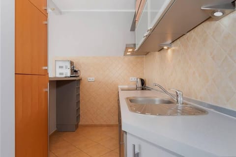 A well-equipped kitchen with wooden cabinets, modern appliances, and a tile backsplash. The layout provides plenty of workspace and storage.