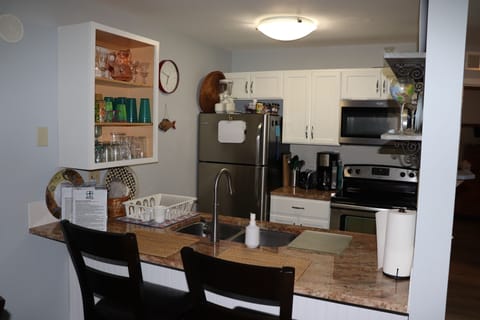 Fully stocked kitchen with glasses and dish ware for 5 people.