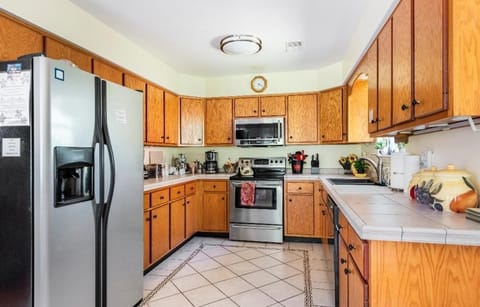 Long view LARGE Kitchen shows generous counter space and appliances, tiled floor