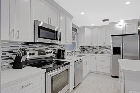 The kitchen is stocked with a full set of appliances including basic kitchen utensils.