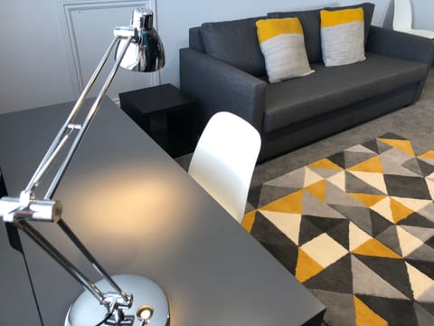 Apartment 5 Living Room with desk & angle-poise lamp, perfect for studying.