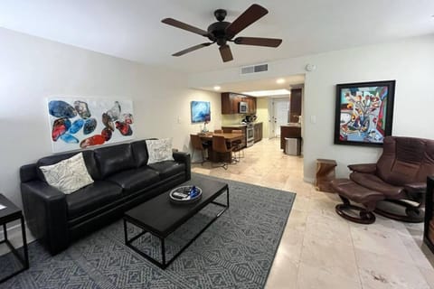 Living room with sofa, TV and doors to the back patio with outdoor furniture