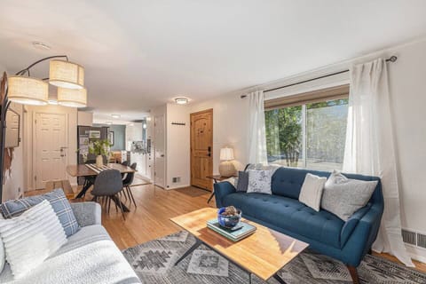- Bright and open living space with a mix of navy and gray seating and large front window
- Natural light fills the room, highlighting the cozy textures and decor
- Flows seamlessly into dining and kitchen areas for group connection

