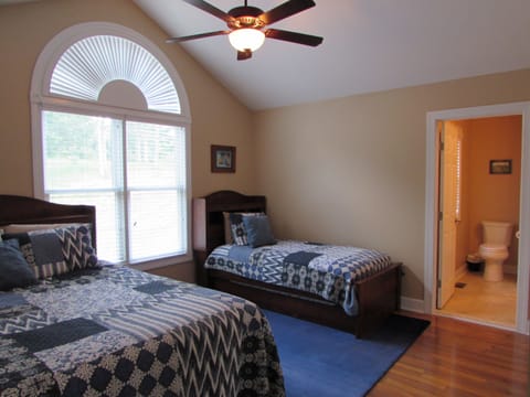 Upstairs second bedroom with queen bed, twin trundle, and private bath.