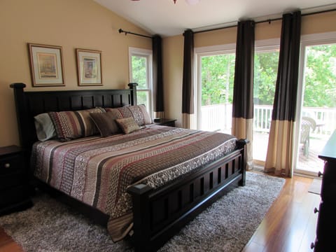 Master bedroom with king bed, TV, master bath, and water views.