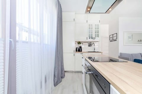A kitchen corner with a small breakfast bar setup, showing a coffee machine and wooden countertops.