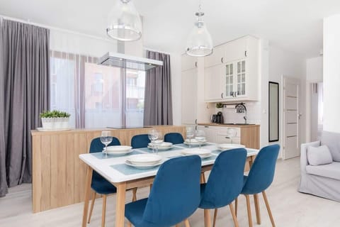 A spacious kitchen area with white cabinets, a countertop, and light coming through a large window.
