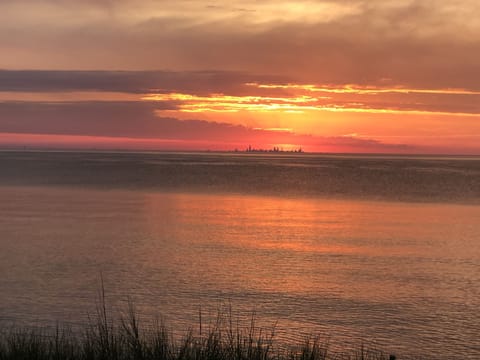 Views of the Chicago skyline across the lake while the sun sets.