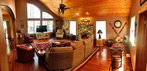 Large living room with vaulted ceiling open to dining room and kitchen