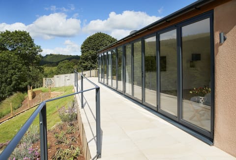 A staggering 16 metres of bi-folding doors opening out to a tiled balcony overlooking the beautiful river