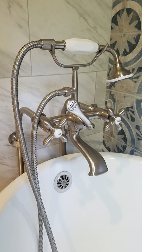 The reproduction antique tub filler has a hand held sprayer.