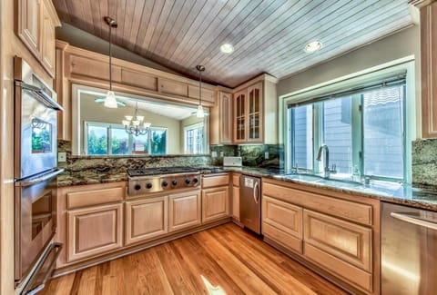 Open kitchen with modern appliances, gas cooktop, electric oven, dishwasher, microwave, coffee maker, and more