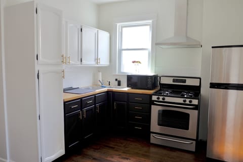 Updated kitchen stocked with glasses, plates, bowls, basic cooking essentials