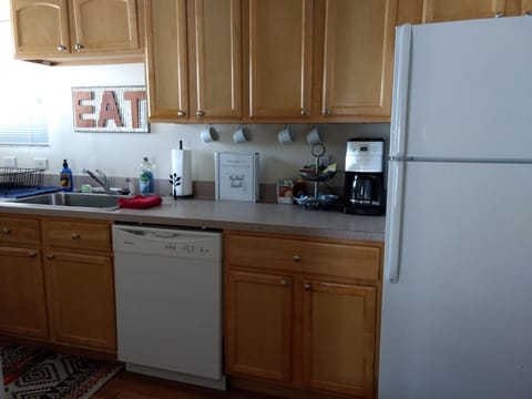 Kitchen with coffee bar, full-sized fridge/freezer, dishes and utensils