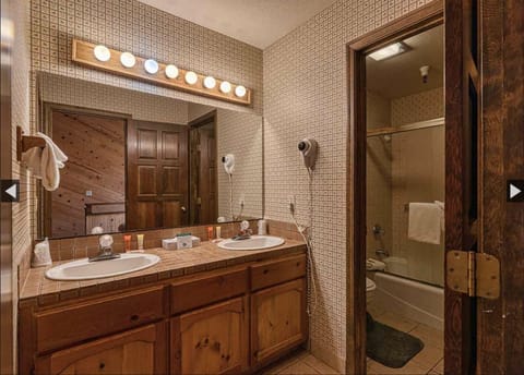 Double sink vanity and two bathrooms, one on each side of the vanities.