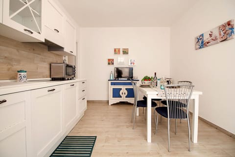 Marina di Grosseto - L'Oblò Apartment - The terrace leads to the kitchen furnished with a dining table and television