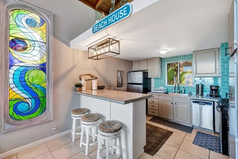 Spacious kitchen with turquoise tile backsplash, perfect for cooking meals with a view.