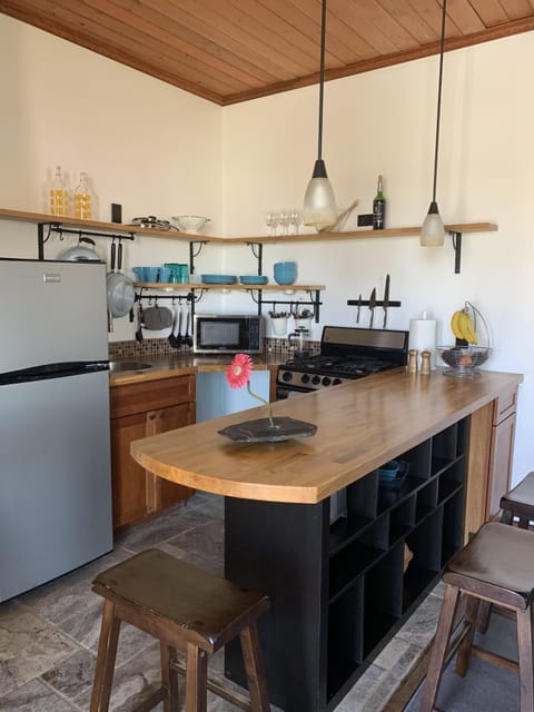 Kitchen with stove, oven, microwave and refrigerator.  Seating for four.