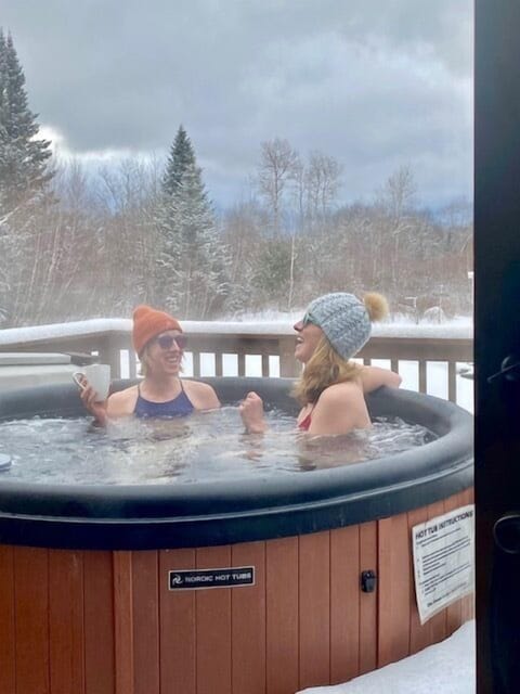 Freelanceadventurer Lindsey enjoying the hot tub on a snowy winter day
