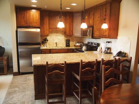 Fully-stocked kitchen with granite countertops and stainless steel appliances
