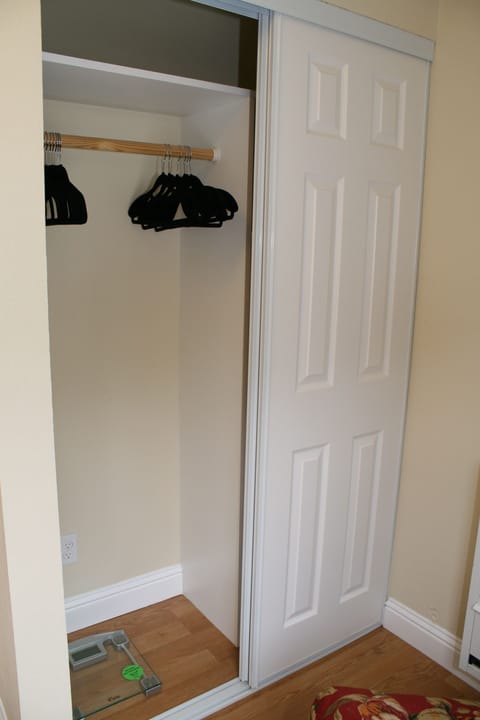 Sun room closet, one side hanging the other shelves with baskets, and hamper