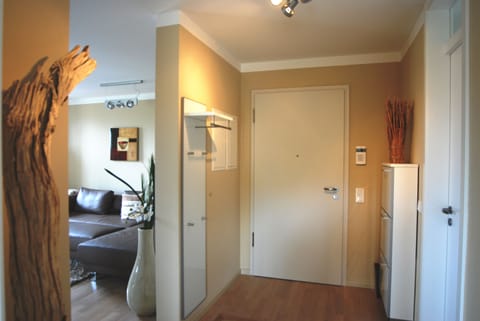 hallway with a coar rack and a shoe box