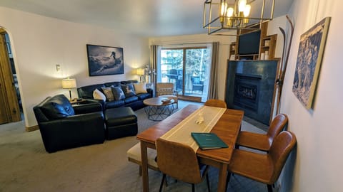 BC West I-2 Living room with gas fireplace, dining table, and balcony w/ gas BBQ