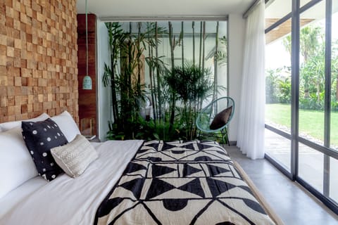 Bedroom with1 king bed, lounge chair, pool and garden views