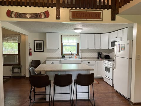 Kitchen fully stocked with silverware, cookware, dishes, and cups.