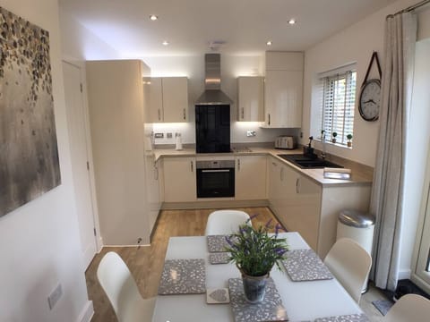 Bright modern kitchen diner with French doors opening onto the garden. High chair available on request.