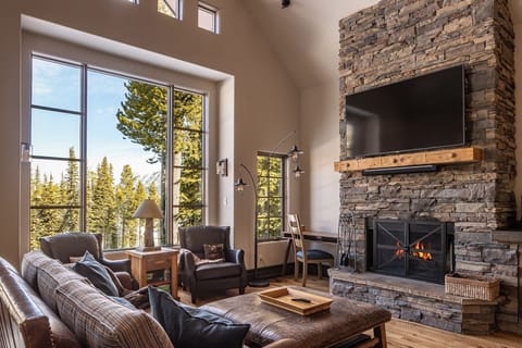 Sink into cozy leather seating by your crackling fireplace while taking in stunning mountain views through floor-to-ceiling windows.