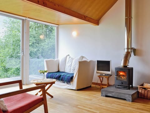 The woodburning stove makes the wood-floored, wood-celienged living area feel warm and cosy | West Bothy at Cluain Ghrianach, Laga, near Acharacle