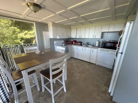 New bar height kitchen table. Newer stove. Cookware for preparing meals.