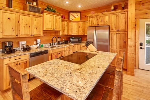 island with stove built in to island and high top chairs.