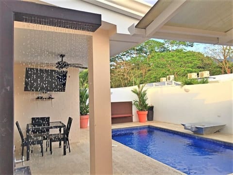 Pool area with dining table, LED TV and coral stone deck