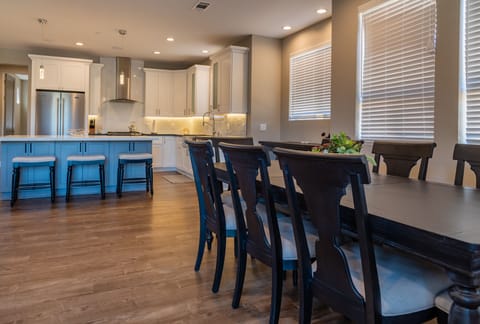 Alternate view of dining table and bar area with 3 barstools