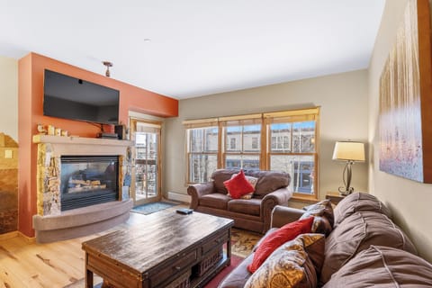 Cozy up by your stone fireplace with plush leather seating, perfect for après-ski relaxation with mountain views.